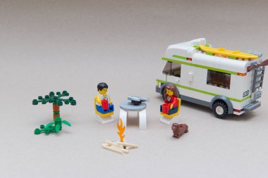 Florianopolis - Brezilya, 14 Haziran 2020: Bisiklet ve karavanın yakınındaki açık hava kampında balık yemek için masada oturan birkaç küçük figür.. Seçici odaklanma. Küçük rakamlar Lego Grubu tarafından üretiliyor.