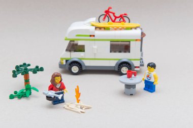 Florianopolis - Brezilya, 14 Haziran 2020: piknik masalı bir kamp ateşinin yanında aile kampı ve bisikletli bir karavan. Seçici odaklanma. Küçük rakamlar Lego Grubu tarafından üretiliyor..