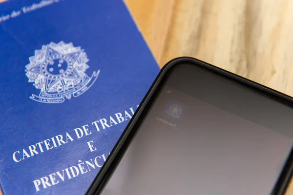 Florianopolis, Brezilya. 27 Haziran 2020: Yazılı ve dijital çalışma ve sosyal güvenlik belgesinin yanı sıra beyaz arka plandaki para faturalarının kapatılması. Resmi istihdam ve devlet yardımları.