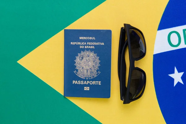 Arka planda Brezilya pasaportu ve güneş gözlüğü manzarası var. Seyahat konsepti. Göç ve göç, turizm ve uluslararası seyahat.
