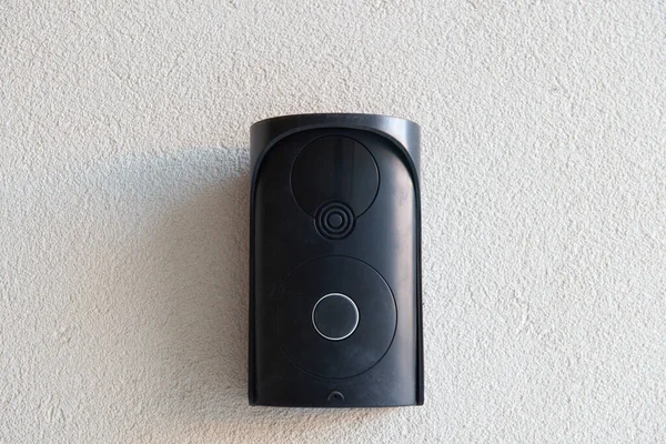 Kaba bej duvarda kamera olmayan siyah bir dahili telefon. Ev koruması için iletişim sistemi.