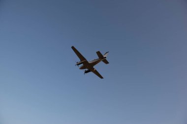 Pervaneli uçağın gün batımında havalanından kalkış görüntüsü. Gökyüzünde uçak silueti.