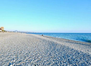 Deniz kıyısında çakıl taşı plajı ve şehri var.
