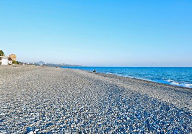 Deniz kıyısında çakıl taşı plajı ve şehri var.