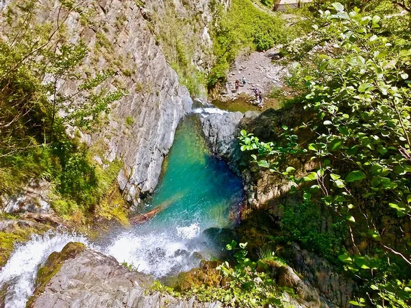 Top view from a cliff to a waterfall with green water