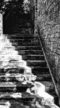 Kulenin gri basamakları yukarı doğru ilerliyor. Üzerlerinde karanlık bir gölge var.