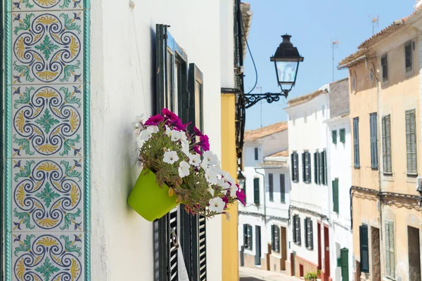 Decorative tiles and flowers in small street at Alaior, Menorca