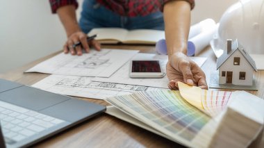 İç mimar, ofisteki ev boyama seçimleri için renk örnekleri çizelgesini şablonla seçiyor. İnşaat konsepti.