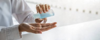 Koronavirüs bulaşmasın diye Asyalı kadın elini alkol dezenfektanı ile yıkıyor. Tıbbi ve Sağlık Konsepti.