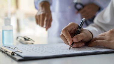 Koronavirüs rapor formunu dolduran Asyalı bir kadın hastanede tavsiye edilen bir doktorla. Tıbbi ve Sağlık Konsepti.