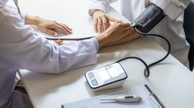 Klinikte ya da hastane ofisinde hastanın tansiyonunu ölçen bir doktor. Tıbbi ve Sağlık Konsepti.