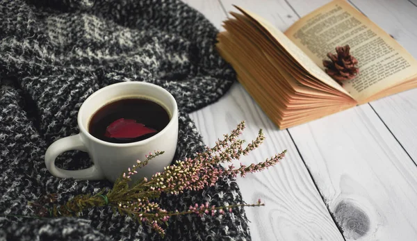 A cup of black coffee with book, flower and red autumn leaf with warm woolen clothes on the brown background. Flat lay, top view, copy space. Autumn cozy composition, fall concept. — Stock Photo, Image