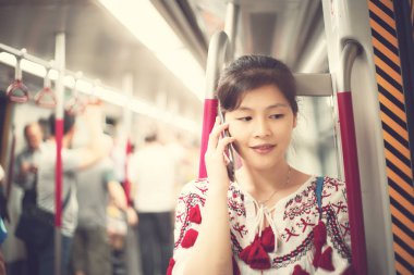 Şehirde cep telefonu kullanan genç bir kadın.