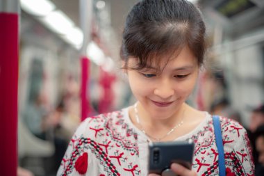 Şehirde cep telefonu kullanan genç bir kadın.