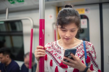 Şehirde cep telefonu kullanan genç bir kadın.