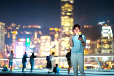 Hong Kong şehir geceleri sokak smarphone kullanan genç kadın