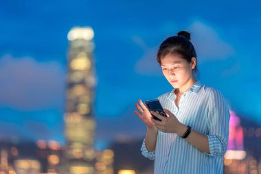 Hong Kong şehir geceleri sokak smarphone kullanan genç kadın