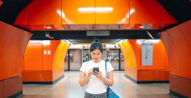 Şehirde cep telefonu kullanan genç bir kadın.