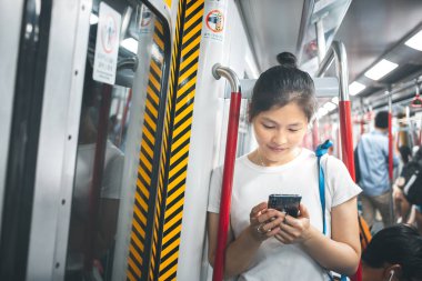 Şehirde cep telefonu kullanan genç bir kadın.