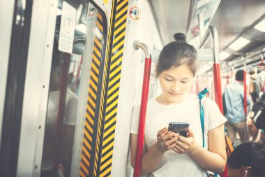 Şehirde cep telefonu kullanan genç bir kadın.