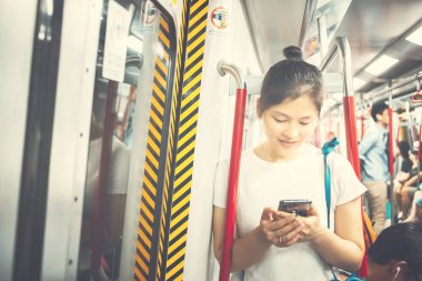 Şehirde cep telefonu kullanan genç bir kadın.