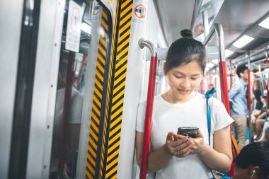 Şehirde cep telefonu kullanan genç bir kadın.