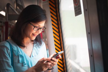 Tren içinde Smartphone kullanan genç kadın