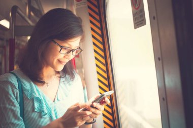 Tren içinde Smartphone kullanan genç kadın