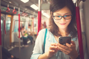 Tren içinde Smartphone kullanan genç kadın