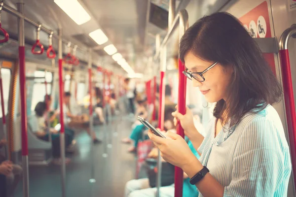 Woman using smartphone in train
