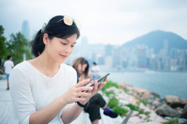 Şehirde akıllı telefon kullanan bir kadın.