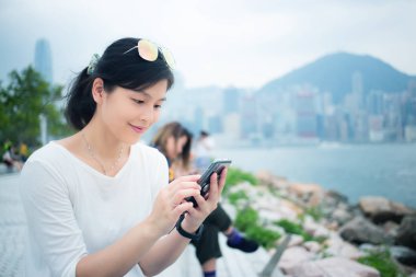Şehirde akıllı telefon kullanan bir kadın.