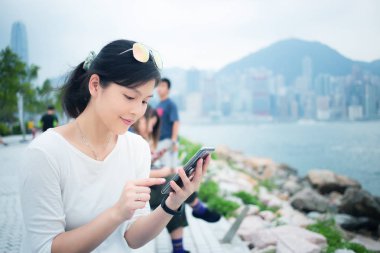 Şehirde akıllı telefon kullanan bir kadın.