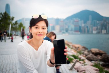 Şehirde akıllı telefon kullanan bir kadın.