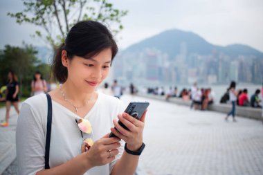 Şehirde akıllı telefon kullanan bir kadın.