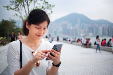 Şehirde akıllı telefon kullanan bir kadın.