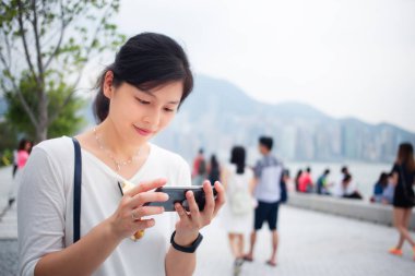 Asyalı kadın Hong Kong şehirde Smartphone kullanarak