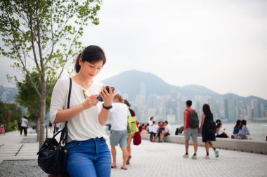 Asyalı kadın Hong Kong şehirde Smartphone kullanarak