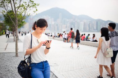 Asyalı kadın Hong Kong şehirde Smartphone kullanarak