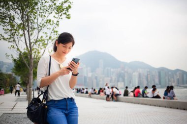 Asyalı kadın Hong Kong şehirde Smartphone kullanarak