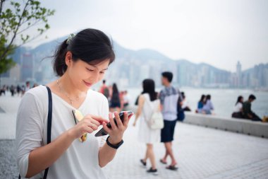 Asyalı kadın Hong Kong şehirde Smartphone kullanarak