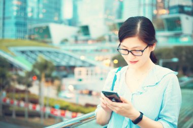 Şehirde Smartphone kullanan genç kadın