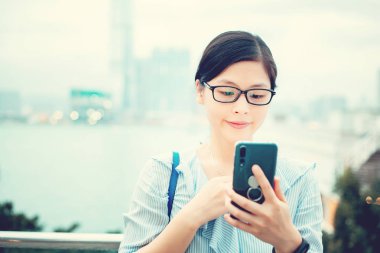 Şehirde Smartphone kullanan genç kadın