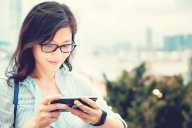 Şehirde Smartphone kullanan genç kadın