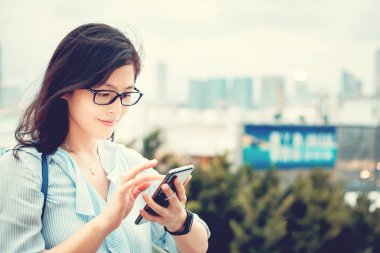 Şehirde Smartphone kullanan genç kadın