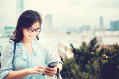Şehirde Smartphone kullanan genç kadın