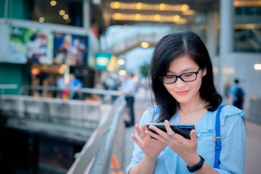 Şehirde Smartphone kullanan genç kadın