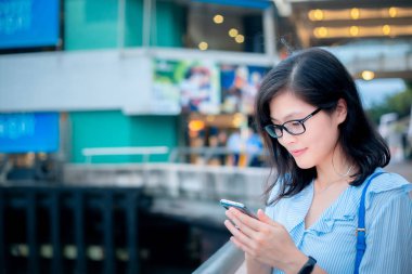 Şehirde Smartphone kullanan genç kadın
