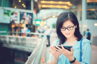 Şehirde Smartphone kullanan genç kadın
