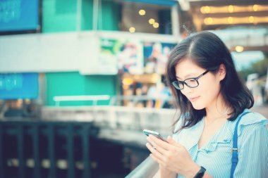 Şehirde Smartphone kullanan genç kadın
